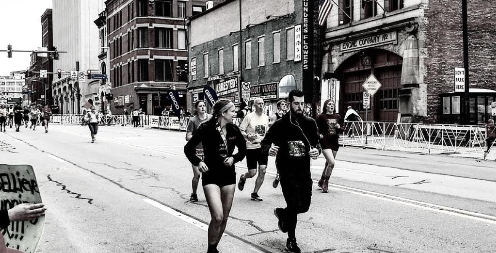 Two runners crossing the city together mid-race